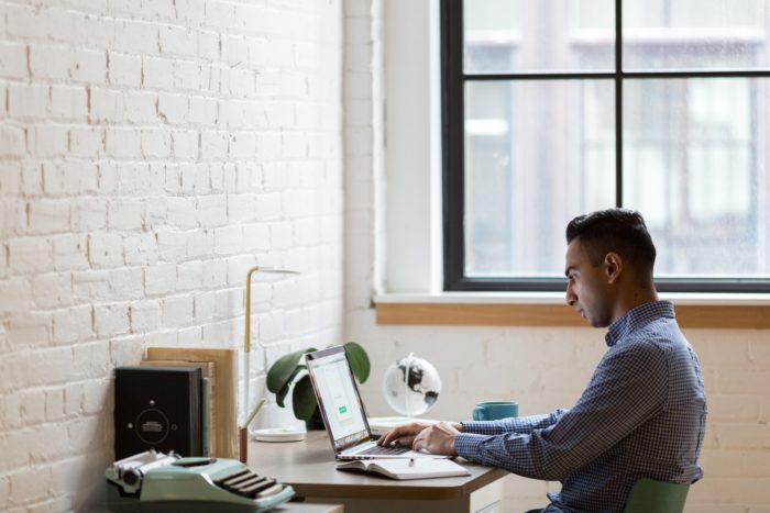 Man Working on Computer Near Window