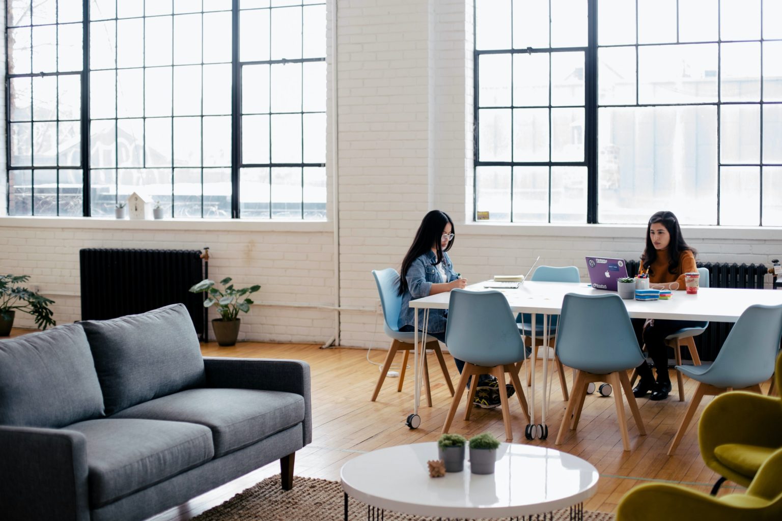 Two women sitting down, working together