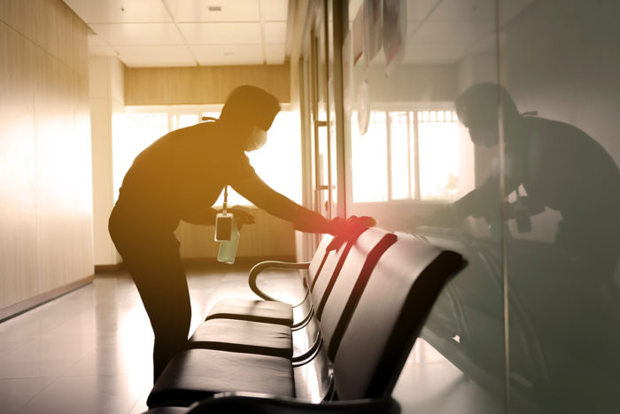 Employee cleaning chair surfaces